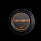 Round black container with gold and silver text on a light gray background
